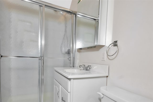 bathroom featuring an enclosed shower, vanity, and toilet