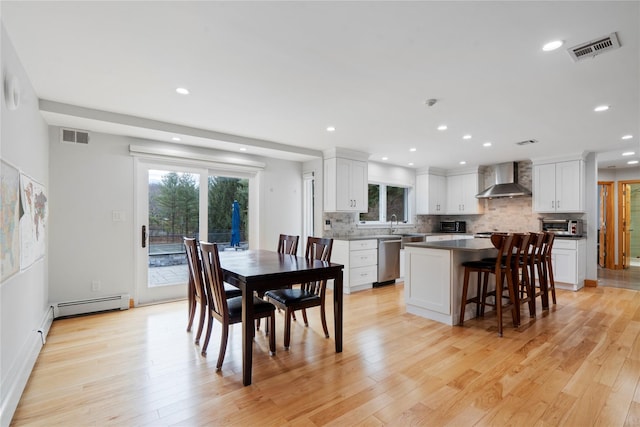 dining room featuring baseboard heating and light hardwood / wood-style floors