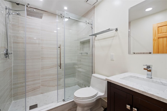 bathroom with vanity, toilet, and a shower with shower door