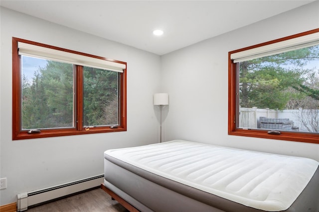 bedroom with hardwood / wood-style flooring and a baseboard radiator