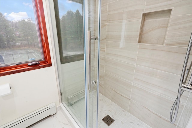 bathroom with tiled shower and a baseboard heating unit