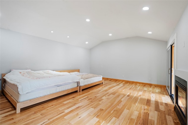 bedroom featuring light wood-type flooring and lofted ceiling