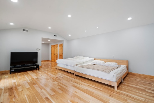 bedroom featuring vaulted ceiling and light wood-type flooring