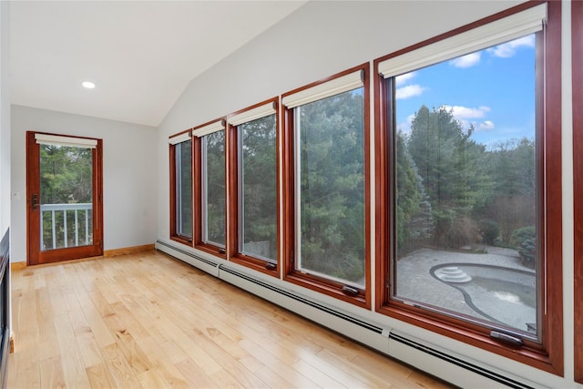 unfurnished sunroom featuring lofted ceiling and baseboard heating