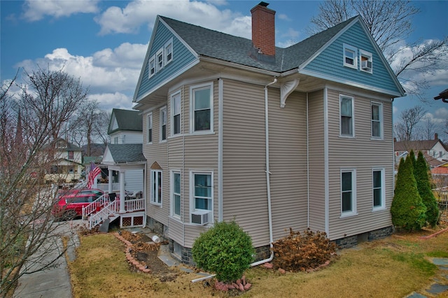 view of side of property with a lawn and cooling unit