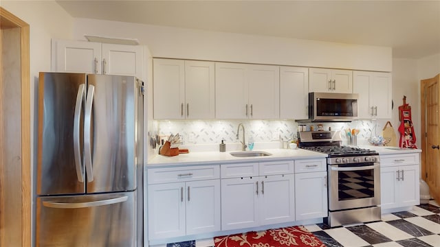 4 Elizabeth St, Port Jervis, NY 12771 - kitchen featuring stainless steel appliances, white cabinetry, light countertops, and decorative backsplash