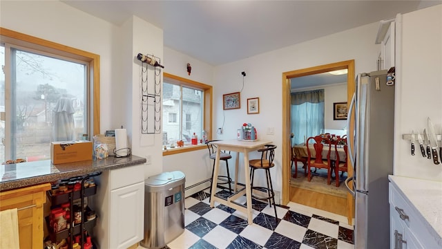 kitchen featuring white cabinetry and stainless steel refrigerator