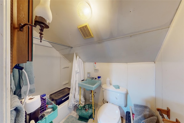 full bathroom featuring toilet,  shower combination, vaulted ceiling, and sink