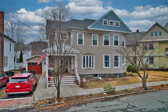 view of front of house featuring a garage and an outbuilding