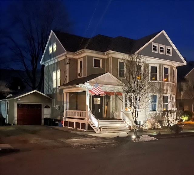 view of front of property featuring a porch, a garage, and an outdoor structure