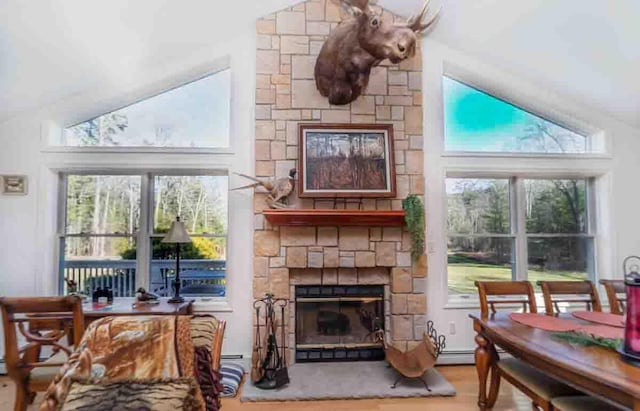 interior space featuring a fireplace, wood-type flooring, high vaulted ceiling, and plenty of natural light