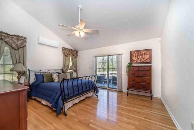 bedroom with ceiling fan, light hardwood / wood-style floors, access to outside, and vaulted ceiling