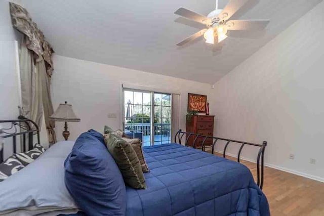 bedroom featuring access to outside, ceiling fan, hardwood / wood-style floors, and vaulted ceiling