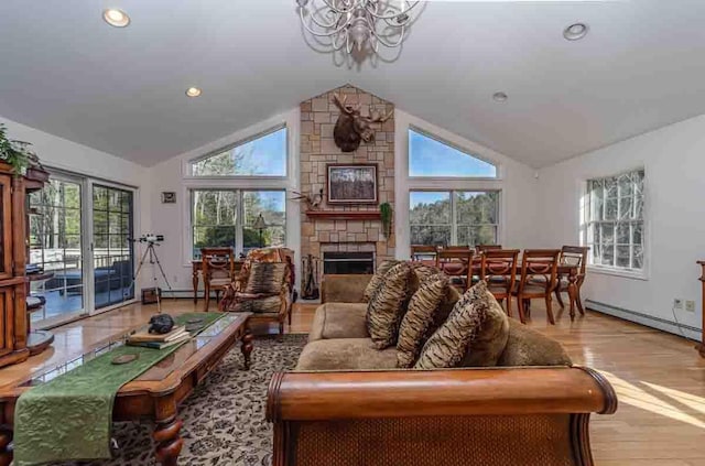 living room with high vaulted ceiling, a baseboard heating unit, an inviting chandelier, light hardwood / wood-style flooring, and a fireplace