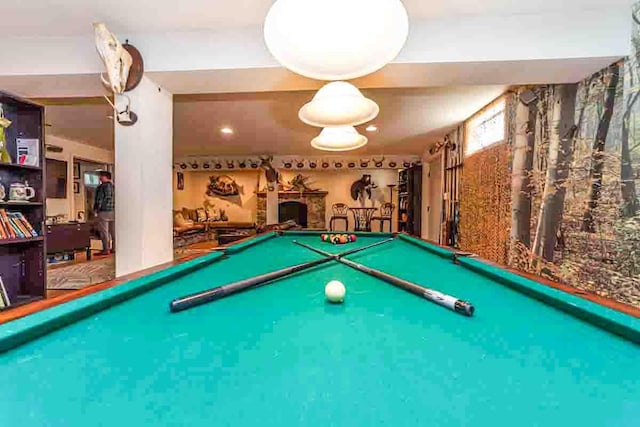 game room with a fireplace and billiards