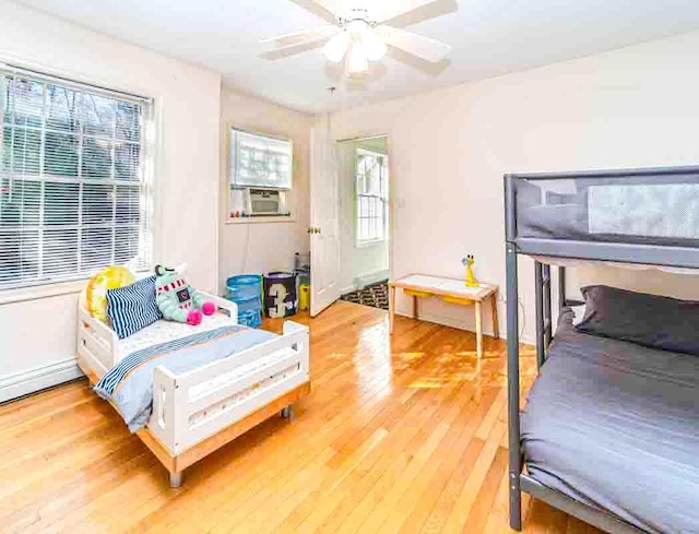 bedroom with wood-type flooring, ceiling fan, and cooling unit