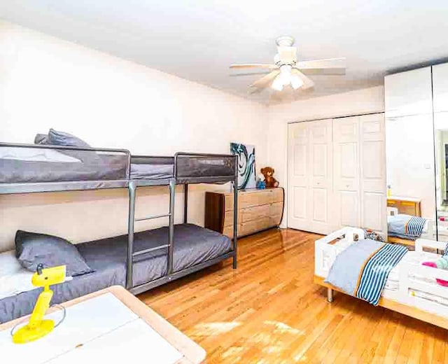 bedroom featuring ceiling fan, a closet, and hardwood / wood-style flooring