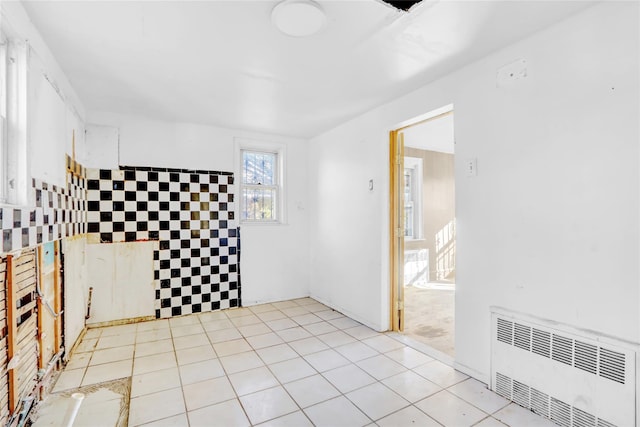 tiled spare room with radiator heating unit