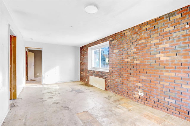 empty room featuring brick wall