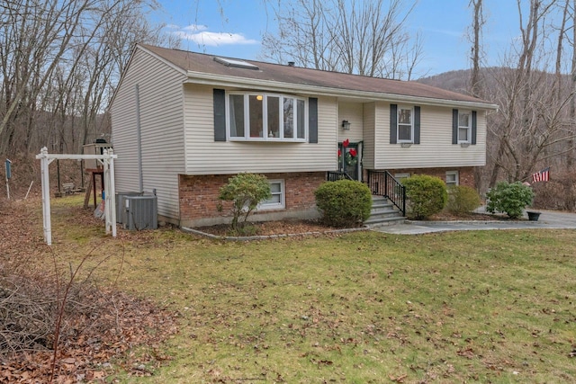 raised ranch with a front yard and central AC