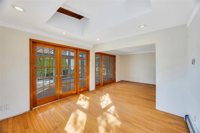 unfurnished room featuring french doors, light hardwood / wood-style floors, baseboard heating, and ornamental molding