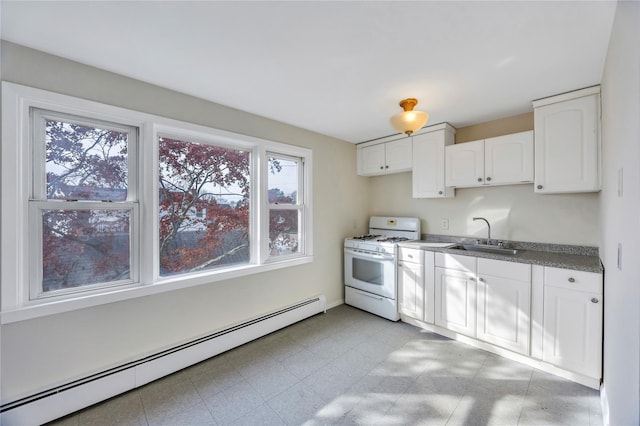 kitchen featuring baseboard heating, a healthy amount of sunlight, sink, and white range with gas stovetop