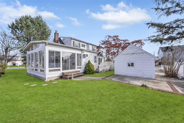 back of property with a patio area, a sunroom, and a yard