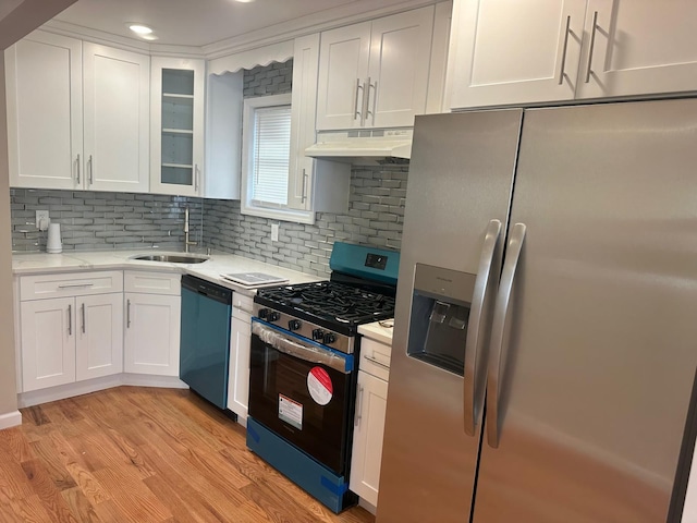 kitchen with white cabinets, sink, stainless steel appliances, and light hardwood / wood-style flooring