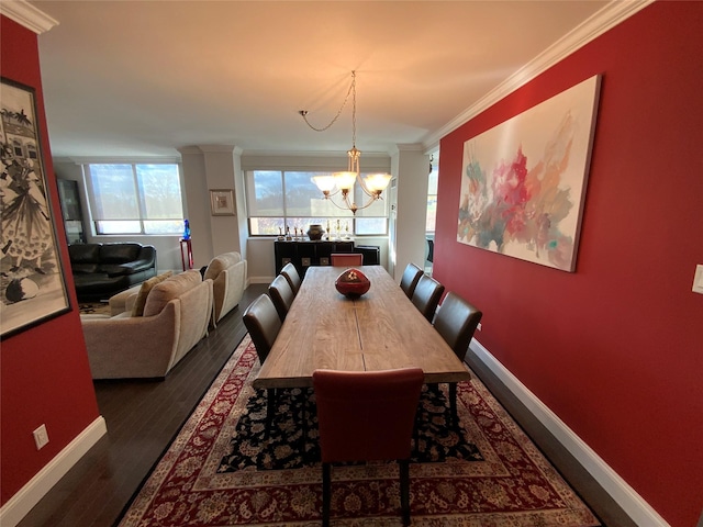 dining room with ornamental molding, an inviting chandelier, and dark wood-type flooring