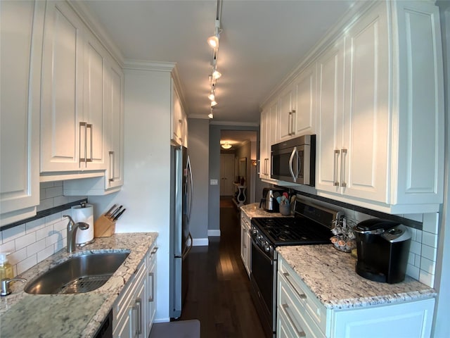 kitchen with sink, stainless steel appliances, backsplash, track lighting, and white cabinets