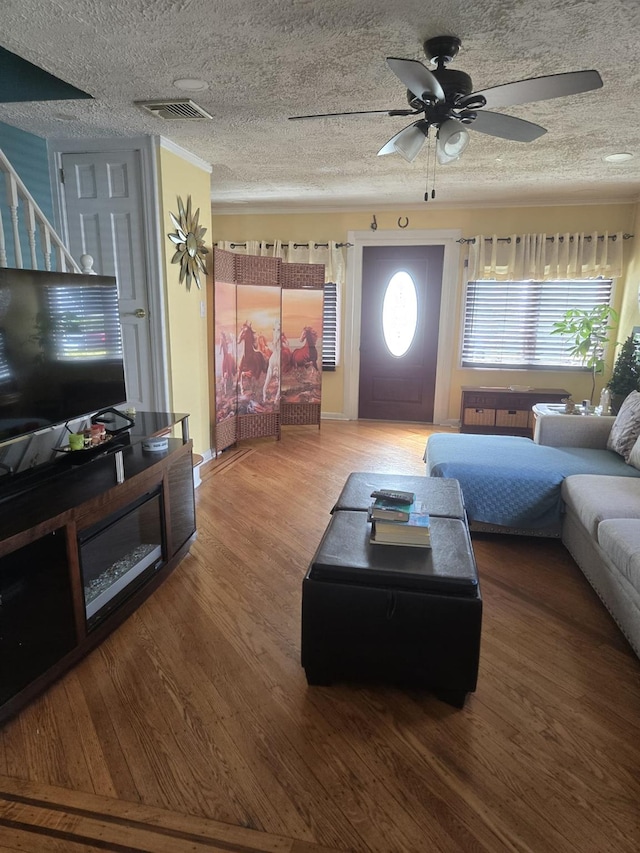 living room featuring ceiling fan, a textured ceiling, and hardwood / wood-style flooring