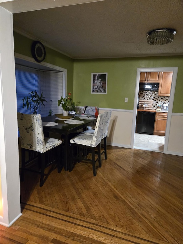 dining area featuring light wood-type flooring and a textured ceiling