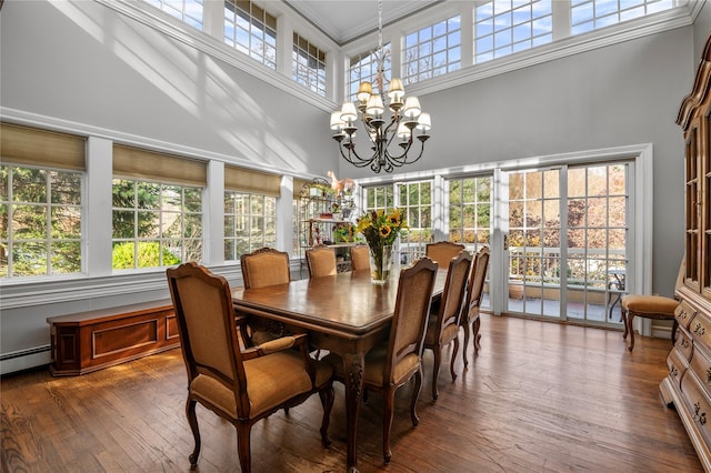 dining space featuring a towering ceiling, plenty of natural light, and a notable chandelier