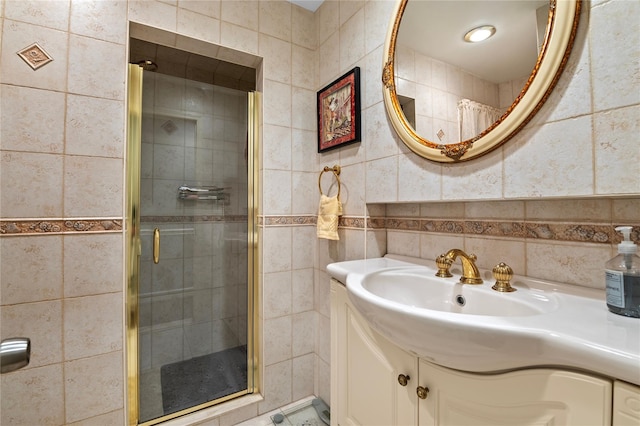 bathroom with vanity, tasteful backsplash, tile walls, and a shower with shower door