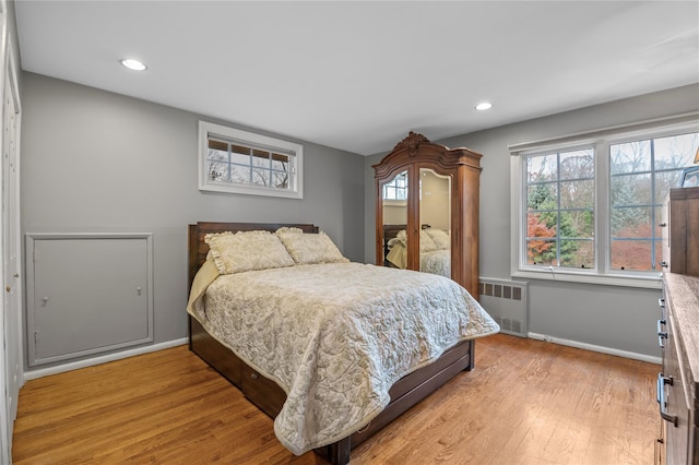 bedroom featuring radiator heating unit and light hardwood / wood-style flooring