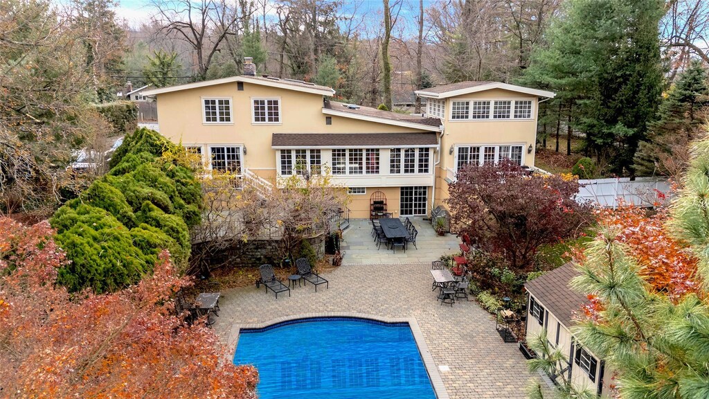 605 Bryant Ave, Roslyn Harbor, NY 11576 - rear view of house featuring a fenced in pool and a patio