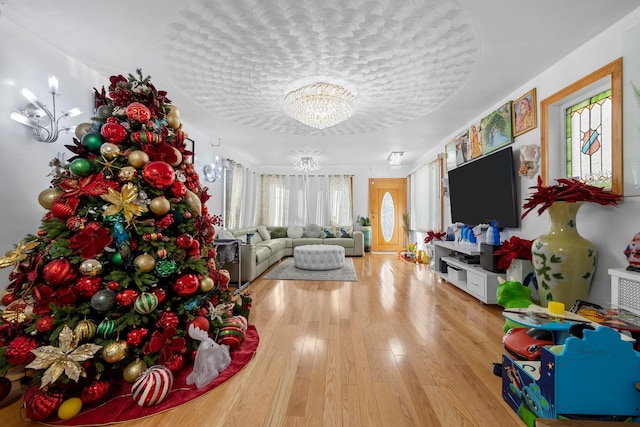 game room with hardwood / wood-style flooring and an inviting chandelier