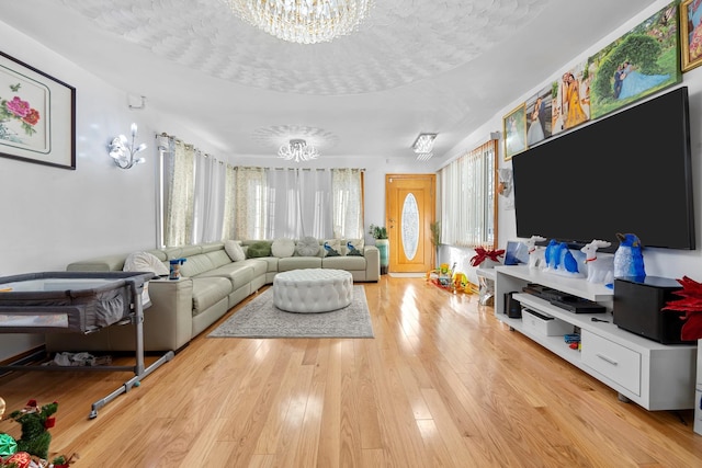 living room with light hardwood / wood-style flooring, a chandelier, and a textured ceiling