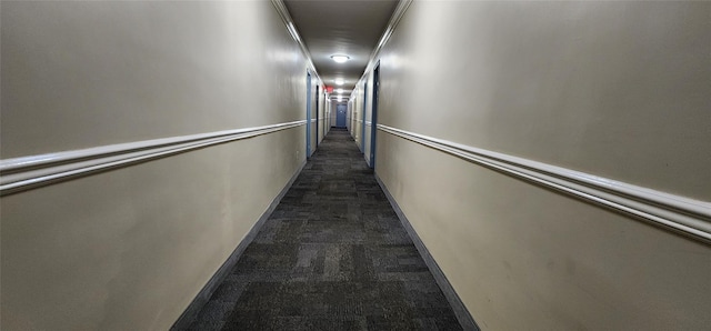 hall with dark carpet and crown molding