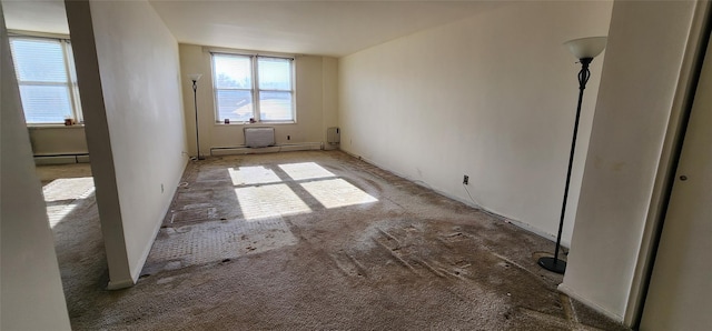 spare room with carpet and a baseboard heating unit