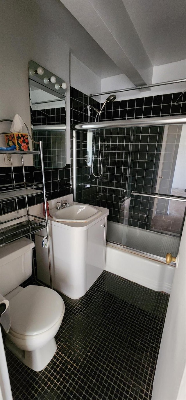 full bathroom with shower / bath combination with glass door, tile patterned floors, vanity, and toilet