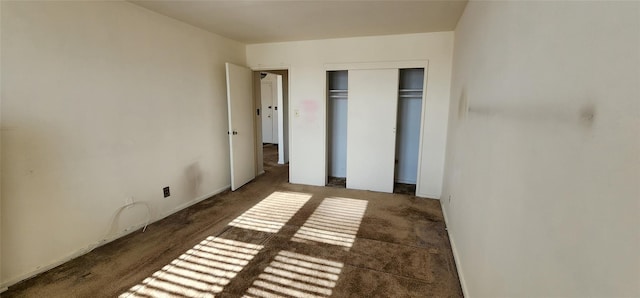 unfurnished bedroom with a closet and dark colored carpet