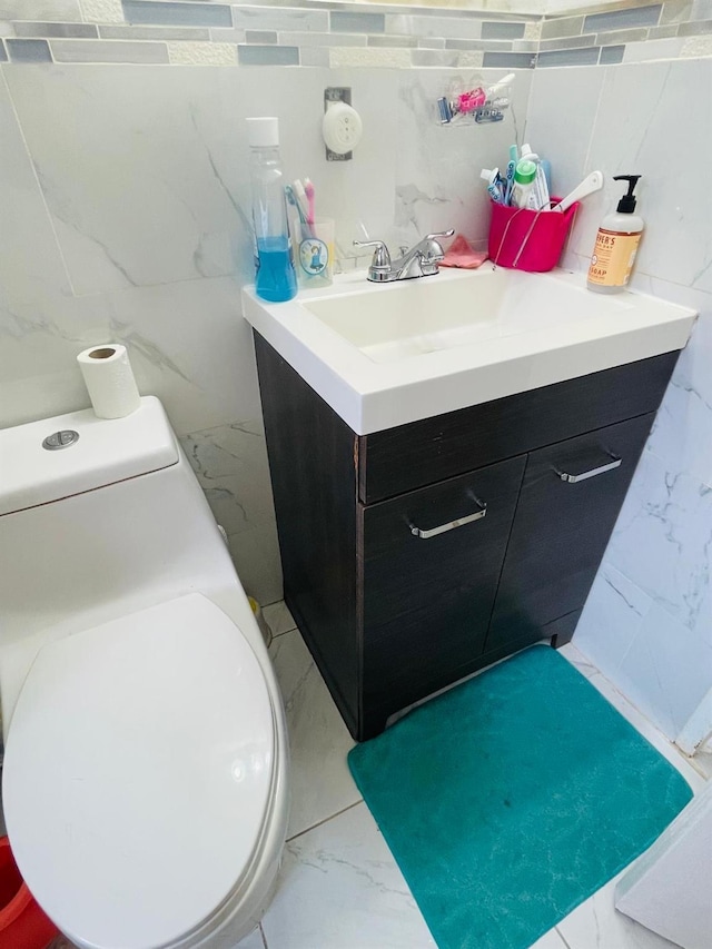 bathroom with toilet, vanity, and backsplash