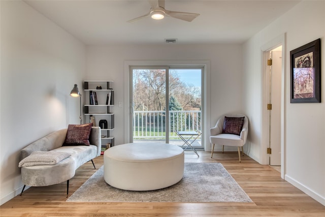 living area with ceiling fan and light hardwood / wood-style flooring