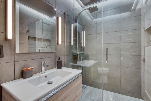 bathroom with an enclosed shower, toilet, tile walls, backsplash, and vanity