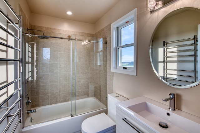 full bathroom with radiator, vanity, shower / bath combination with glass door, and toilet