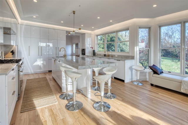 465 Sound Shore Rd, Aquebogue, NY 11901 - kitchen featuring modern cabinets, stainless steel stove, plenty of natural light, light wood-style flooring, and recessed lighting