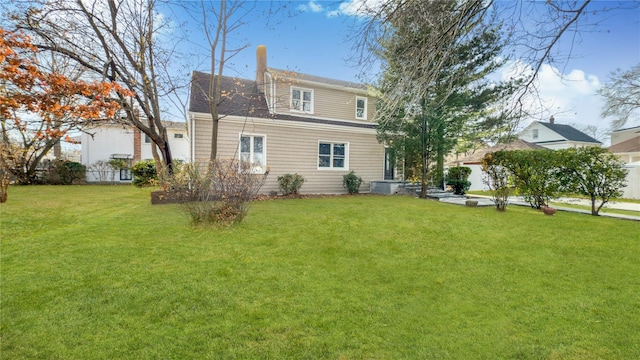 rear view of property featuring a lawn