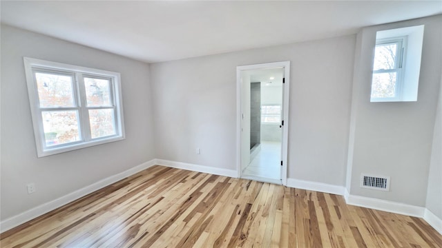 empty room with light hardwood / wood-style flooring and a wealth of natural light