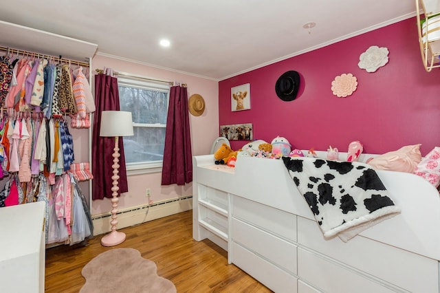 bedroom with crown molding, wood-type flooring, and a baseboard radiator